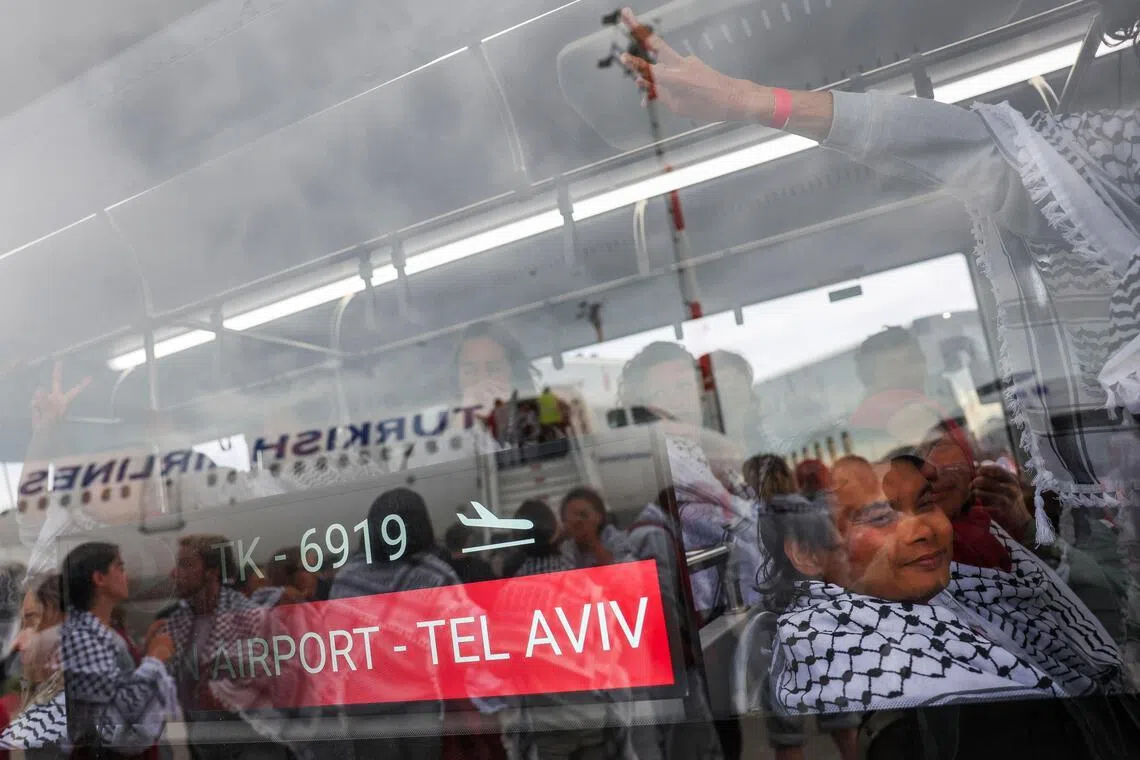 Activists from the Gaza-bound Global Sumud Flotilla sit inside a bus upon arrival at Istanbul Airport, Turkey, on May 21. 
