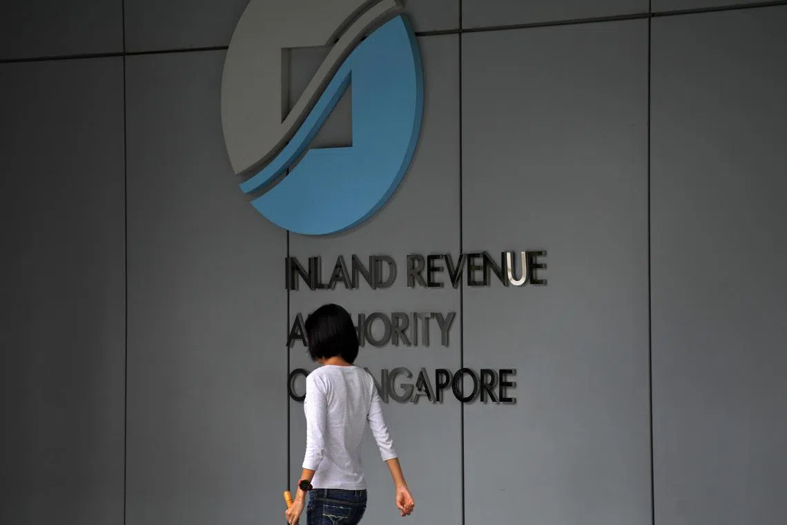 A lady walking past the Inland Revenue Authority of Singapore (IRAS) logo at the IRAS building on 16 February 2017.
