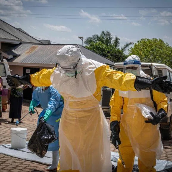 Health workers are sprayed with disinfectant on May 25 after coming into contact with the body of a person suspected of having died from Ebola in Bunia, Democratic Republic of the Congo.