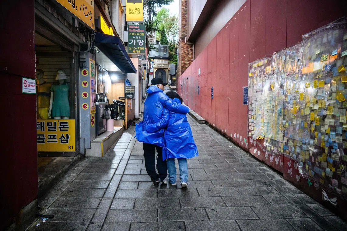 Madam Cho Mi-eun (R) and her husband Lee Jong-chul walking along the alleyway where their 24-year-old son Lee Ji-han was killed during a Halloween crowd crush in the popular Itaewon district of Seoul in October last year.