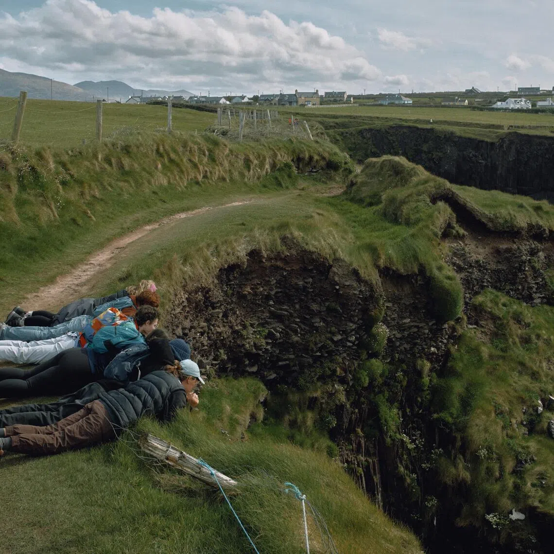 A group of friends peers down at the cliffs and sea in Dingle, Ireland on April 21.