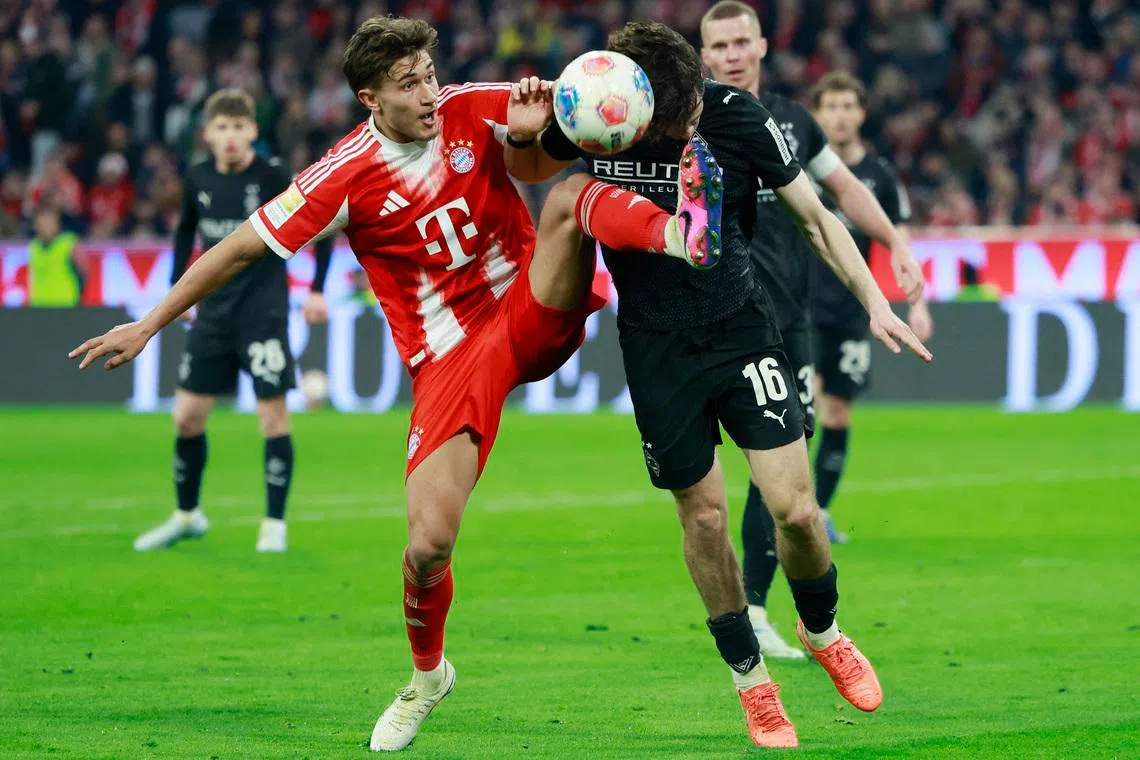 Soccer Football - Bundesliga - Bayern Munich v Borussia Moenchengladbach - Allianz Arena, Munich, Germany - March 6, 2026 Bayern Munich's Tom Bischof in action with Borussia Moenchengladbach's Philipp Sander REUTERS/Heiko Becker