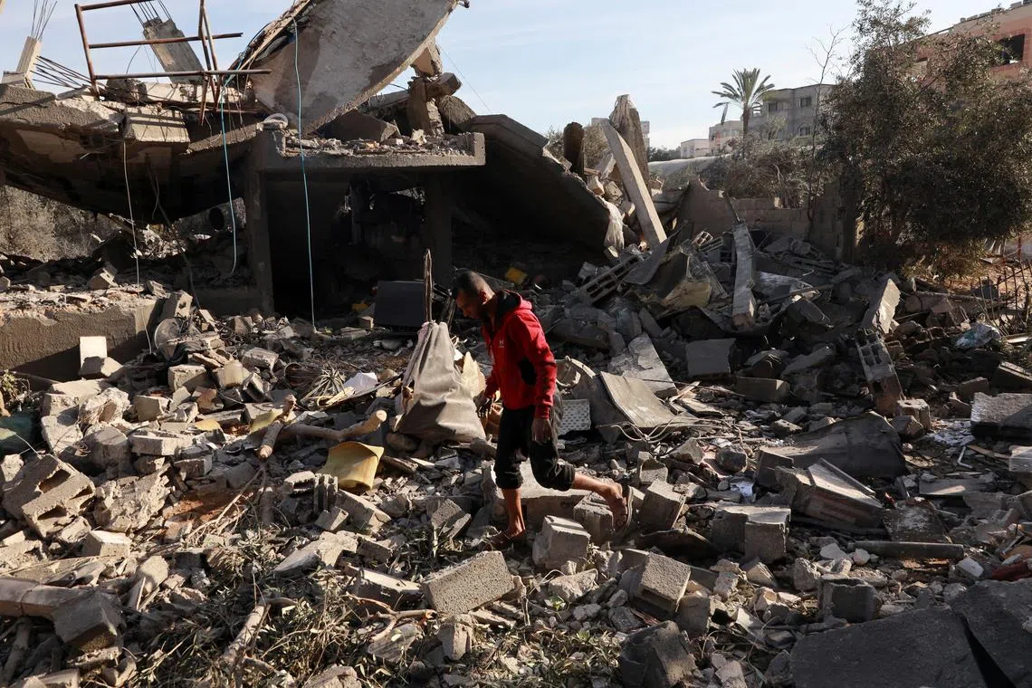 A Palestinian man inspects the site of an Israeli strike on a house, amid the ongoing conflict between Israel and Hamas, in Nuseirat, central Gaza Strip, December 11, 2024. REUTERS/Abd Elhkeem Khaled