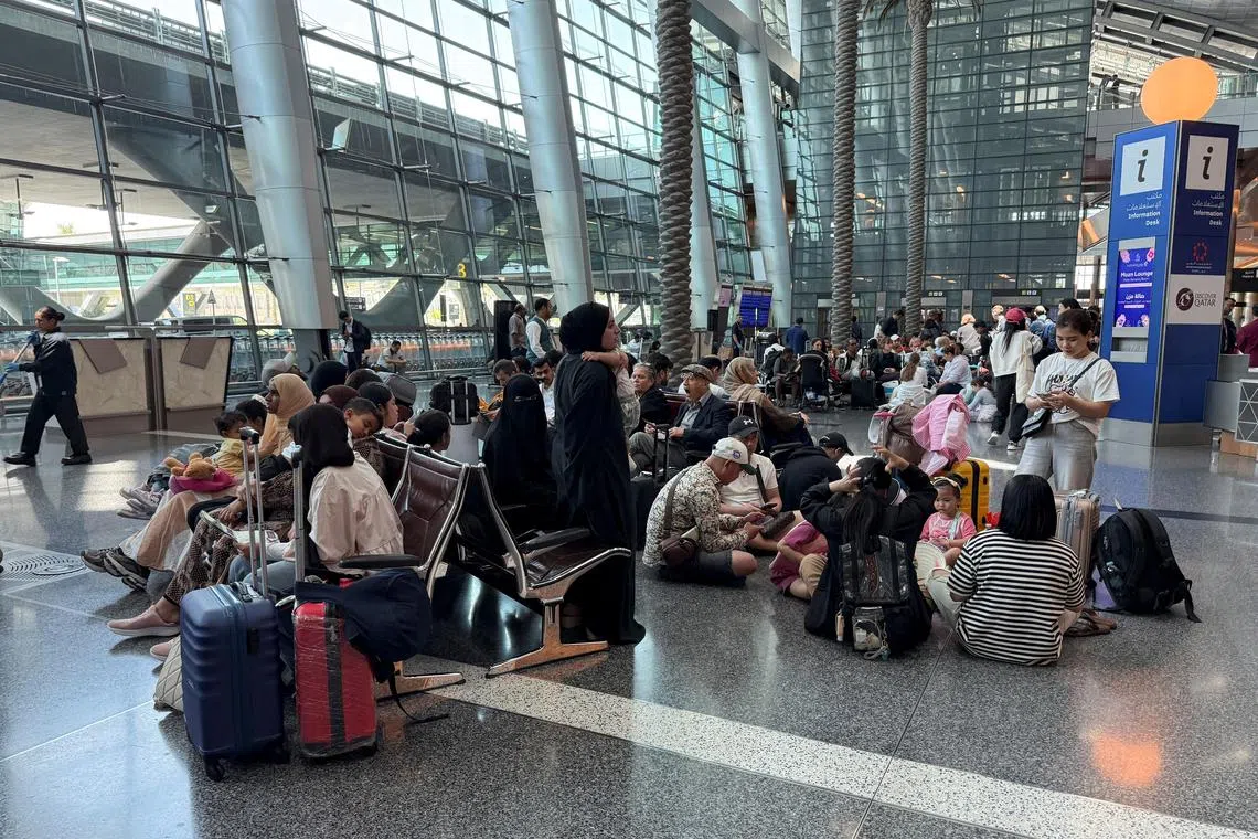People sit at Hamad International Airport after Qatar reopened its airspace following a brief closure in the wake of Iran’s missile attack on Al Udeid Air Base on Monday, in Doha, Qatar, June 24, 2025. REUTERS/Stringer