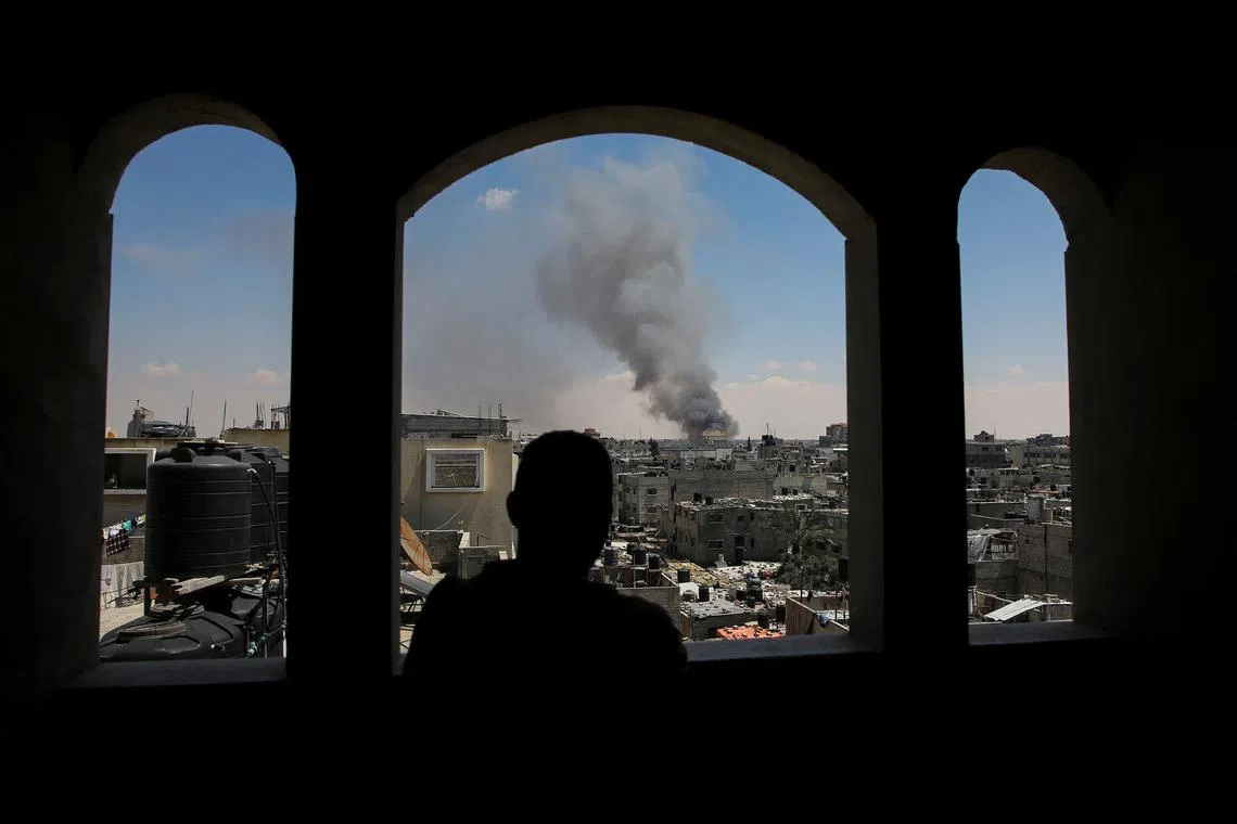 A Palestinian man watches as smoke rises after Israeli strikes while Israeli forces launch a ground and air operation in the eastern part of Rafah, amid the ongoing conflict between Israel and Hamas, in Rafah, in the southern Gaza Strip May 7, 2024. REUTERS/Hatem Khaled
