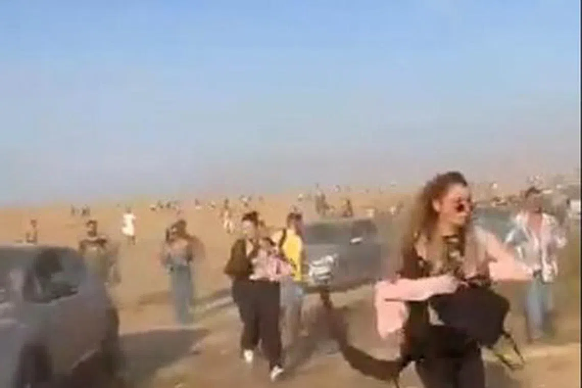 People at a dance party flee during a surprise attack launched by Hamas, near Reim, Israel October 7, 2023 in this screen grab obtained from social media video. Video obtained by Reuters/via REUTERS