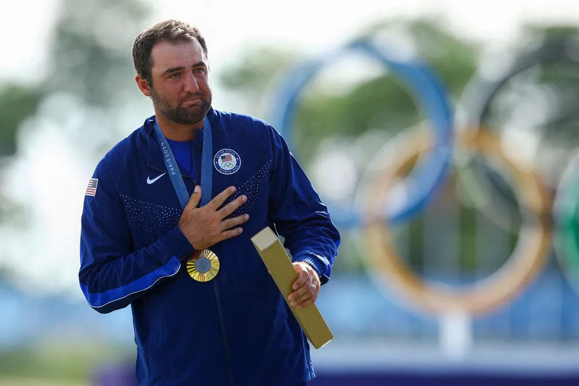 Paris Olympics gold medallist Scottie Scheffler of the US celebrates on the podium at Le Golf National on Aug 4, 2024.