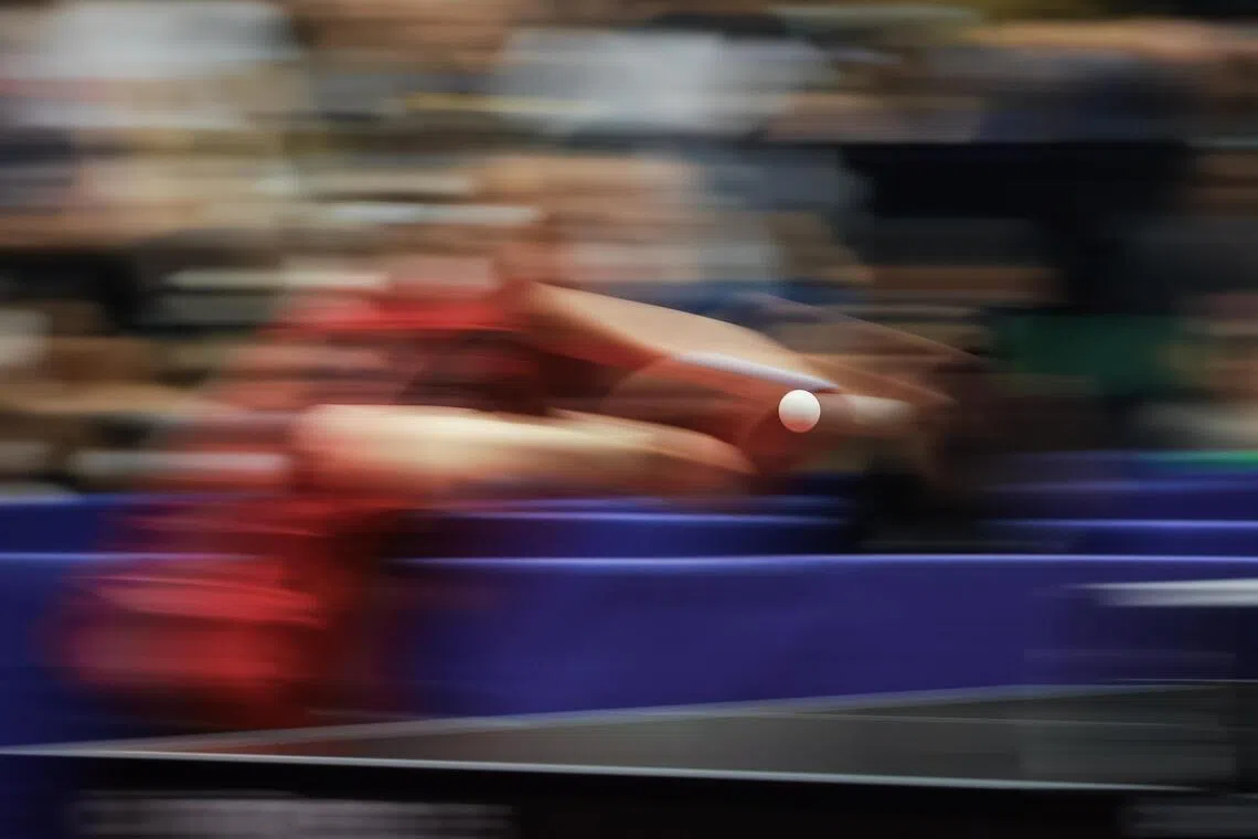 Singapore’s Ser Lin Qian returning a serve from Thailand’s Suthasini Sawettabut in the women’s table tennis team final at Central Westgate in Bangkok on Dec 14. This long-exposure panning shot keeps the fast-moving ping pong ball sharp amid a blurry background, capturing the speed and intensity of the rally.