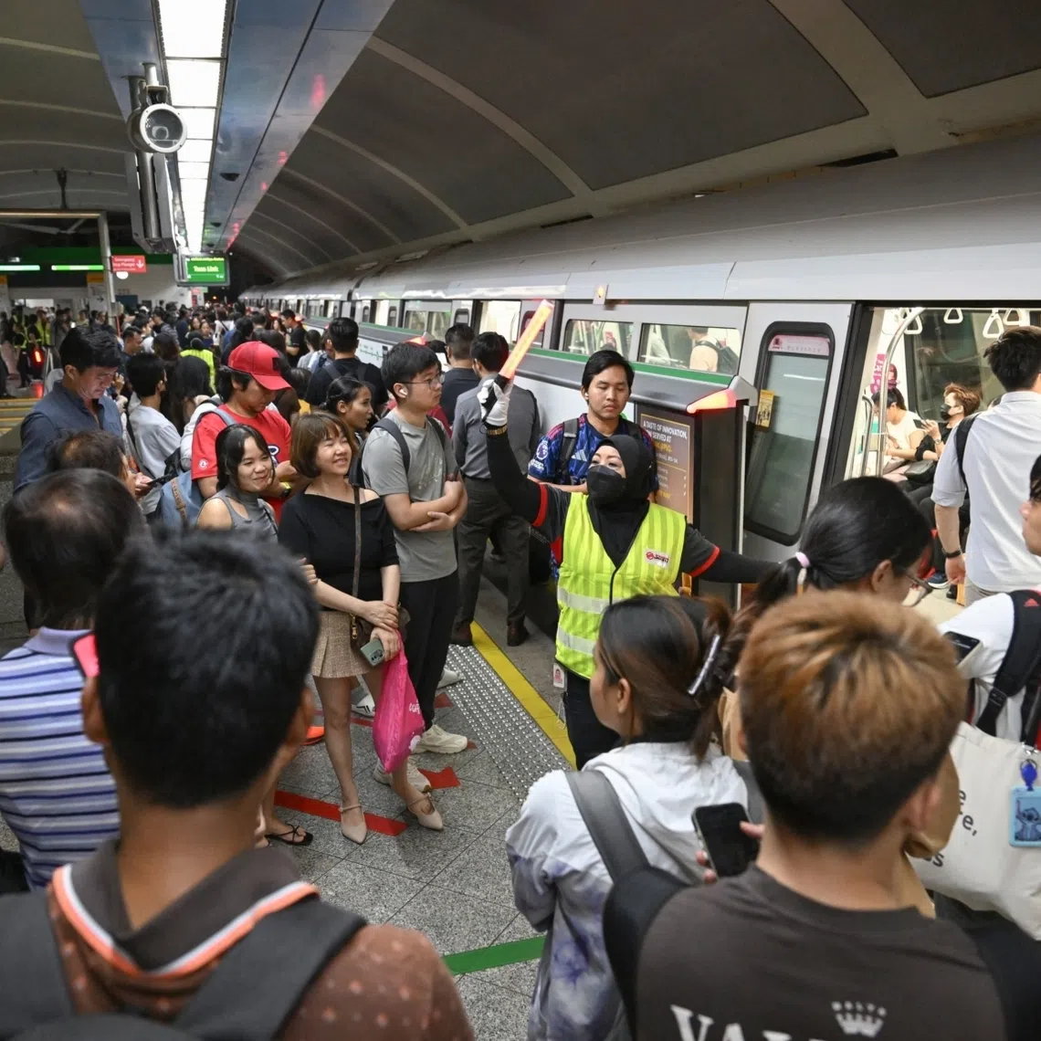 An SMRT employee directing people at Paya Lebar station on Dec 2.
