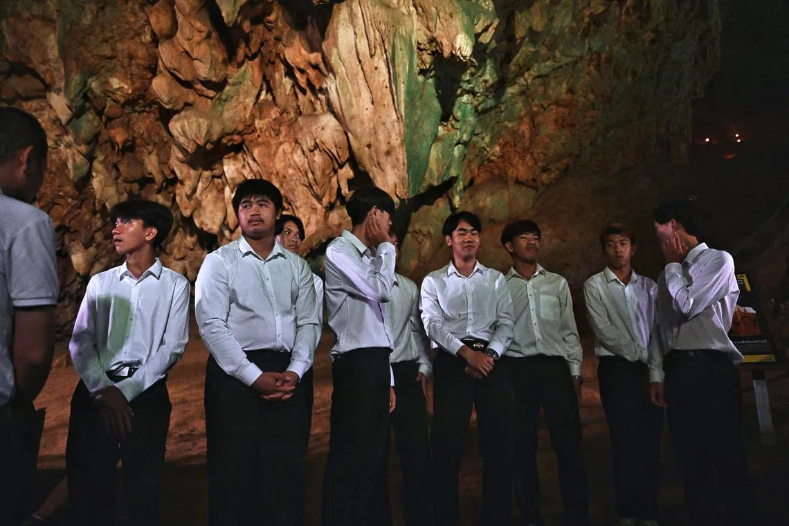TOPSHOT - Members of the Thai "Wild Boars" youth football team gather inside the Tham Luang Cave in Mae Sai district in the northern province of Chiang Rai on July 10, 2023, during an event to mark the five-year anniversary of their rescue from inside the flooded cave. Five years after twelve young footballers trapped in a Thai cave were dramatically pulled to safety in a rescue watched around the world, local officials re-opened more of the site on July 10. (Photo by Lillian SUWANRUMPHA / AFP)