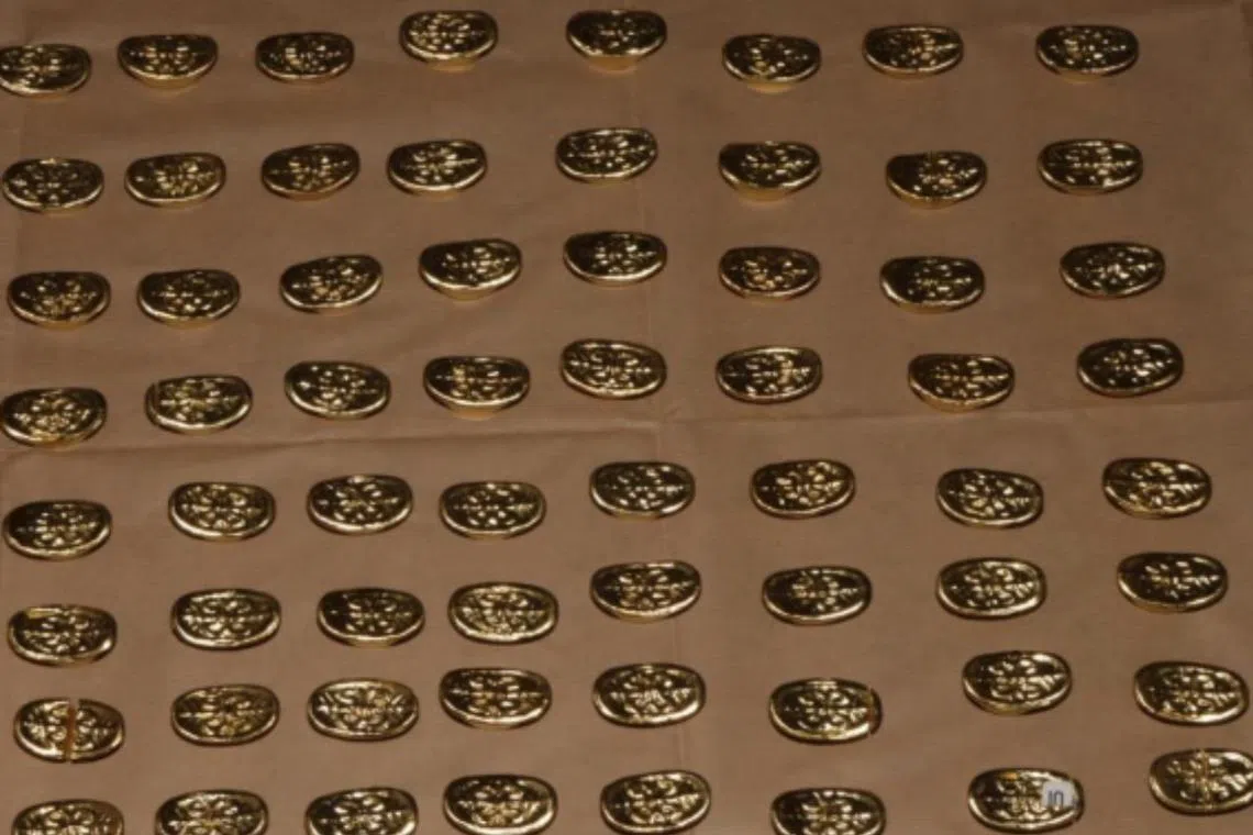 The police seized a number of mini gold-coloured ingots.