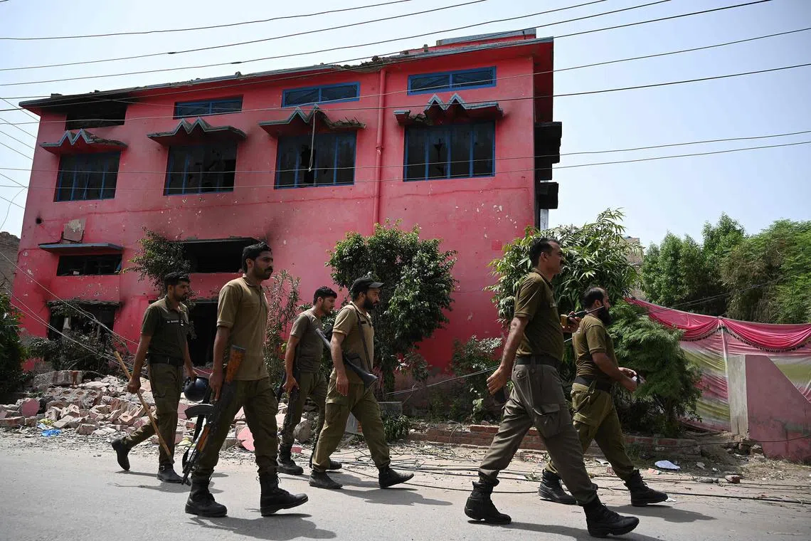 Police officers guarding a damaged Salvation Army church in Jaranwala, on the outskirts of Faisalabad, Pakistan, on Aug 17.