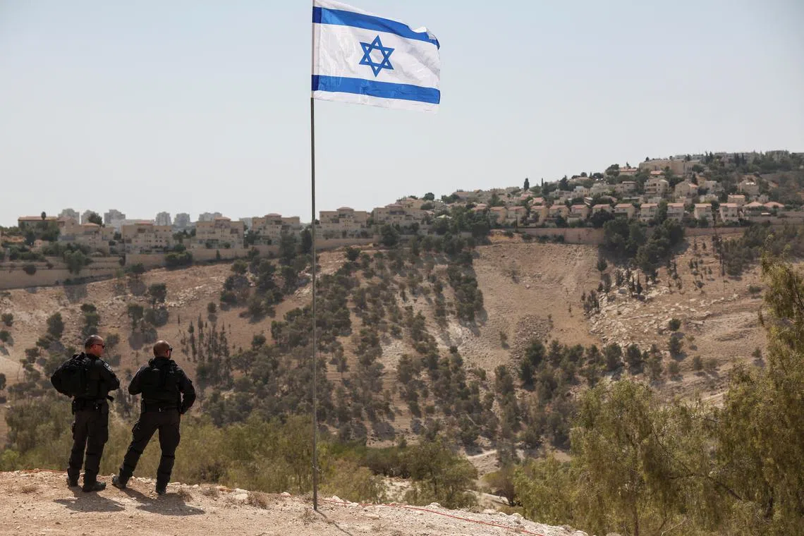 An Israeli flag flutters, as part of the Israeli settlement of Maale Adumim is visible in the background, in the Israeli-occupied West Bank, August 14, 2025. REUTERS/Ronen Zvulun