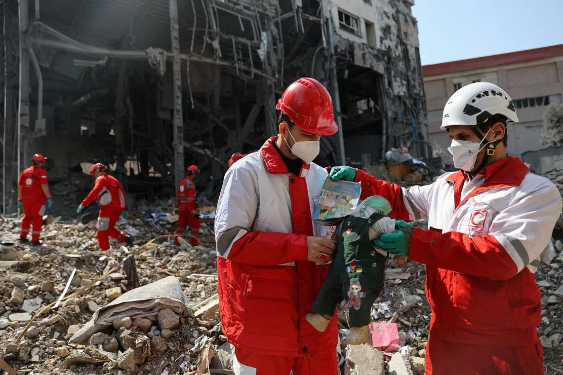 Members of a Red Crescent rescue team hold a doll, at the site of a building that was damaged by a strike, amid the U.S.-Israeli conflict with Iran, in Tehran, Iran, March 17, 2026. Majid Asgaripour/WANA (West Asia News Agency) via REUTERS