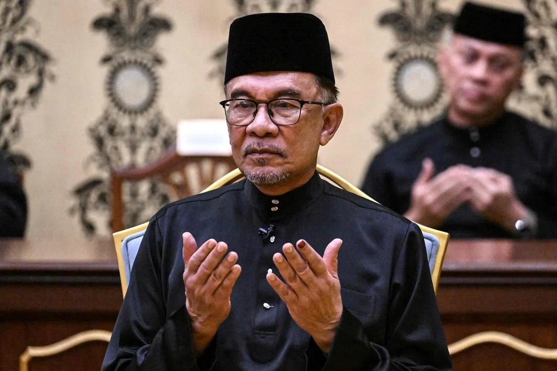Malaysia's new Prime Minister Anwar Ibrahim offers prayers after taking the oath during the swearing-in ceremony, on Nov 24, 2022.