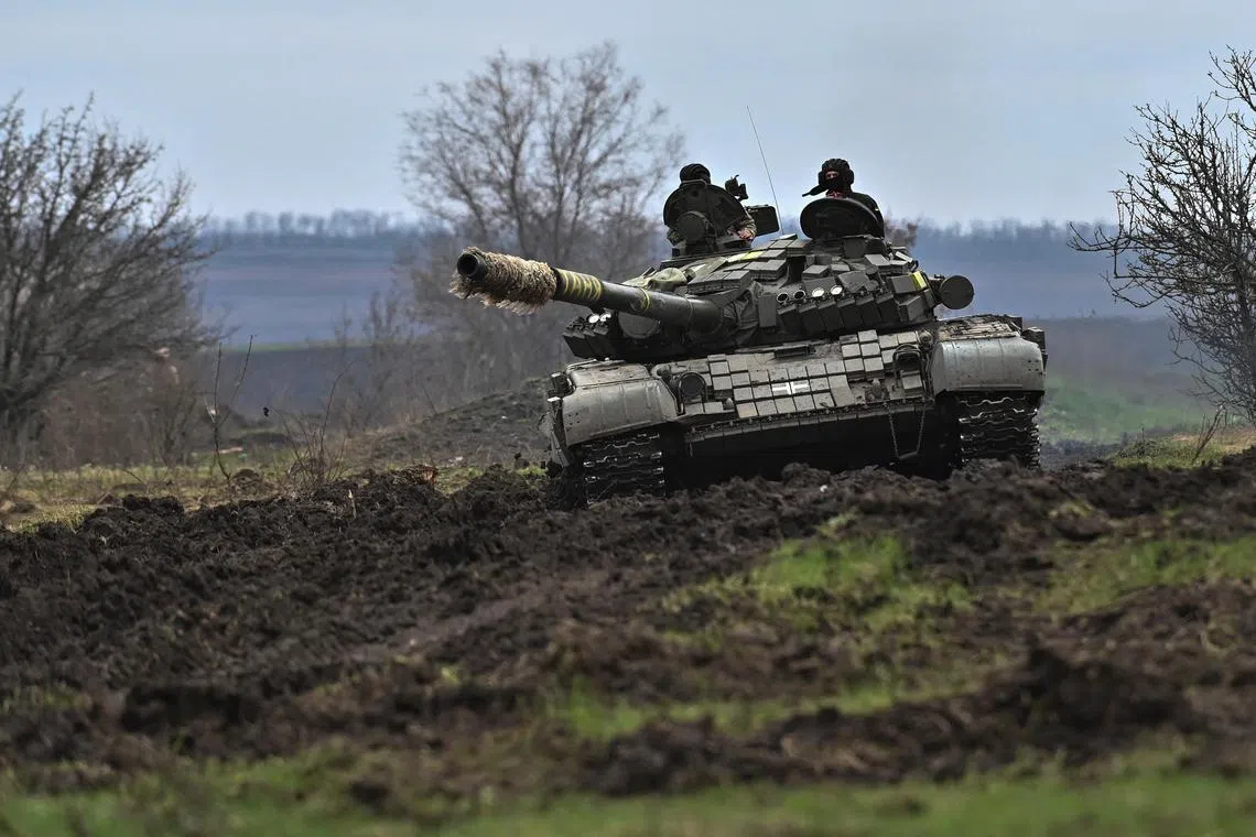 Ukrainian servicemen ride atop a tank during military training in Ukraine's Zaporizhzhia region, on March 29, 2023.