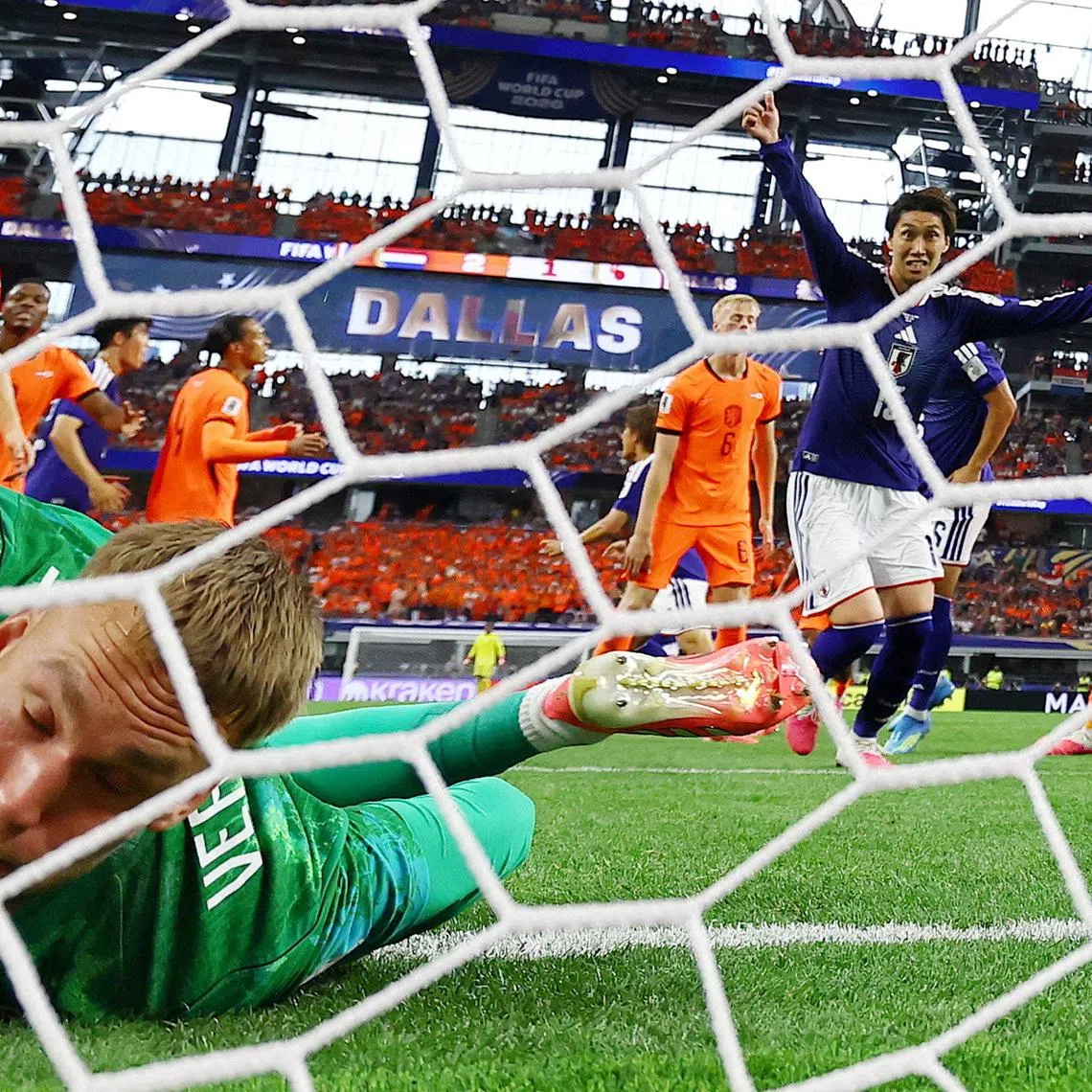 Japan's Daichi Kamada celebrates scoring their second goal as Netherlands' Bart Verbruggen reacts.