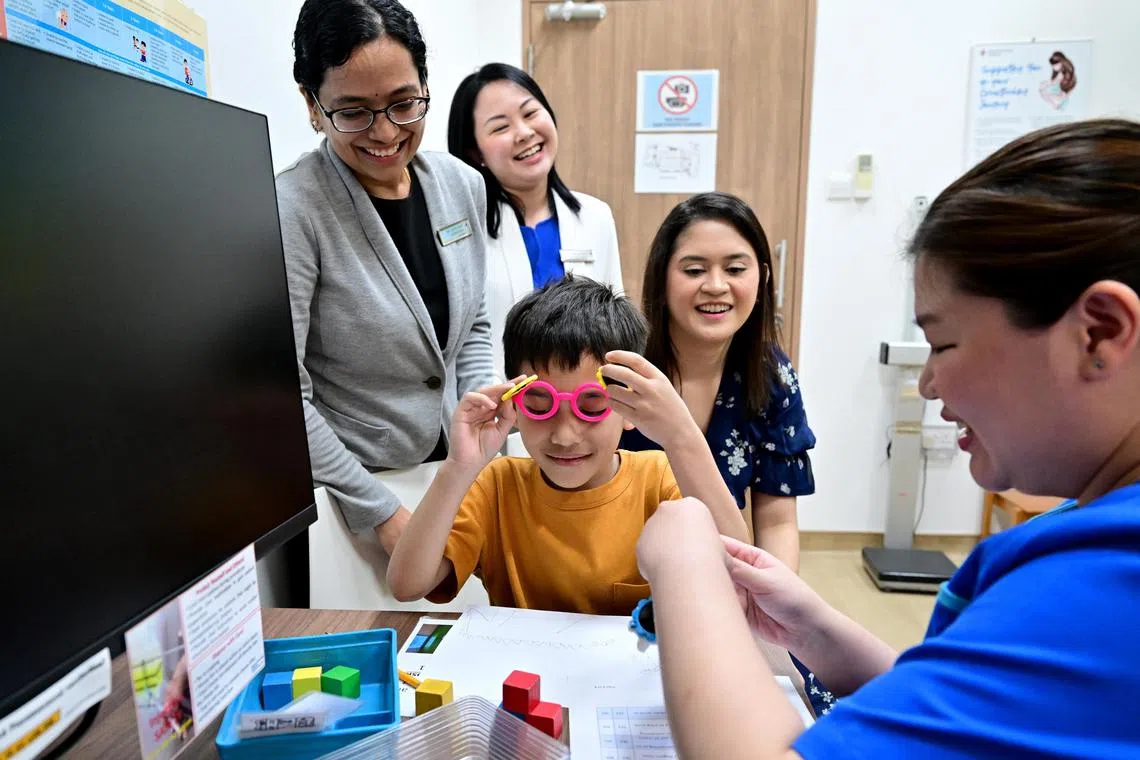 Dr Aishworiya Ramkumar (in grey jacket), a consultant with the Child Development Unit of the National University Hospital’s Khoo Teck Puat-National University Children’s Medical Institute, and National University Polyclinics senior consultant family physician Dr Ruth Zheng (in white jacket), together with Pioneer Polyclinic nurse manager Ms Ong Li Ping (in blue uniform), Ms Suhaila Nor Osman and her son, Qaiser Fikri, who has autism. 

Dr Ramkumar and Dr Zheng are authors of a study on the effectiveness of an autism screening tool,  the Modified Checklist for Autism in Toddlers, Revised with Follow-Up (M-CHAT-R/F) questionnaire. 