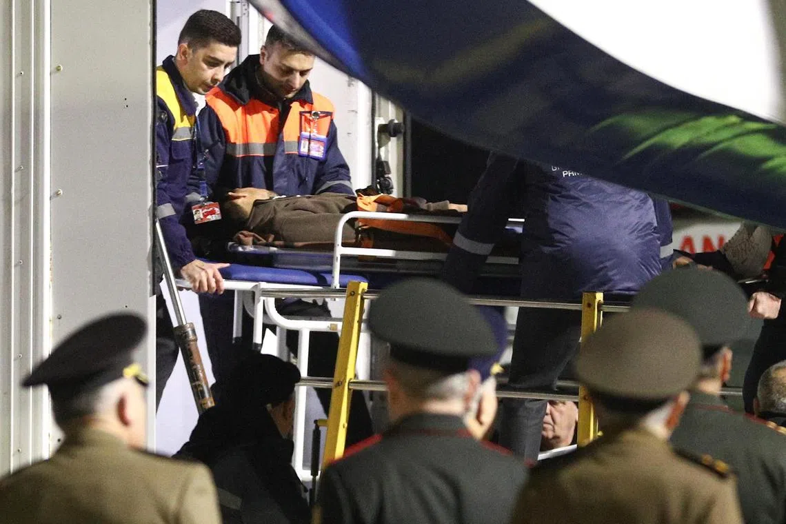 A passenger of the Azerbaijan Airlines' Embraer plane, who was injured in a plane crash near the Kazakh city of Aktau, is transported on a stretcher into an ambulance upon the arrival at an airport in Baku, Azerbaijan, December 26, 2024. REUTERS/Aziz Karimov