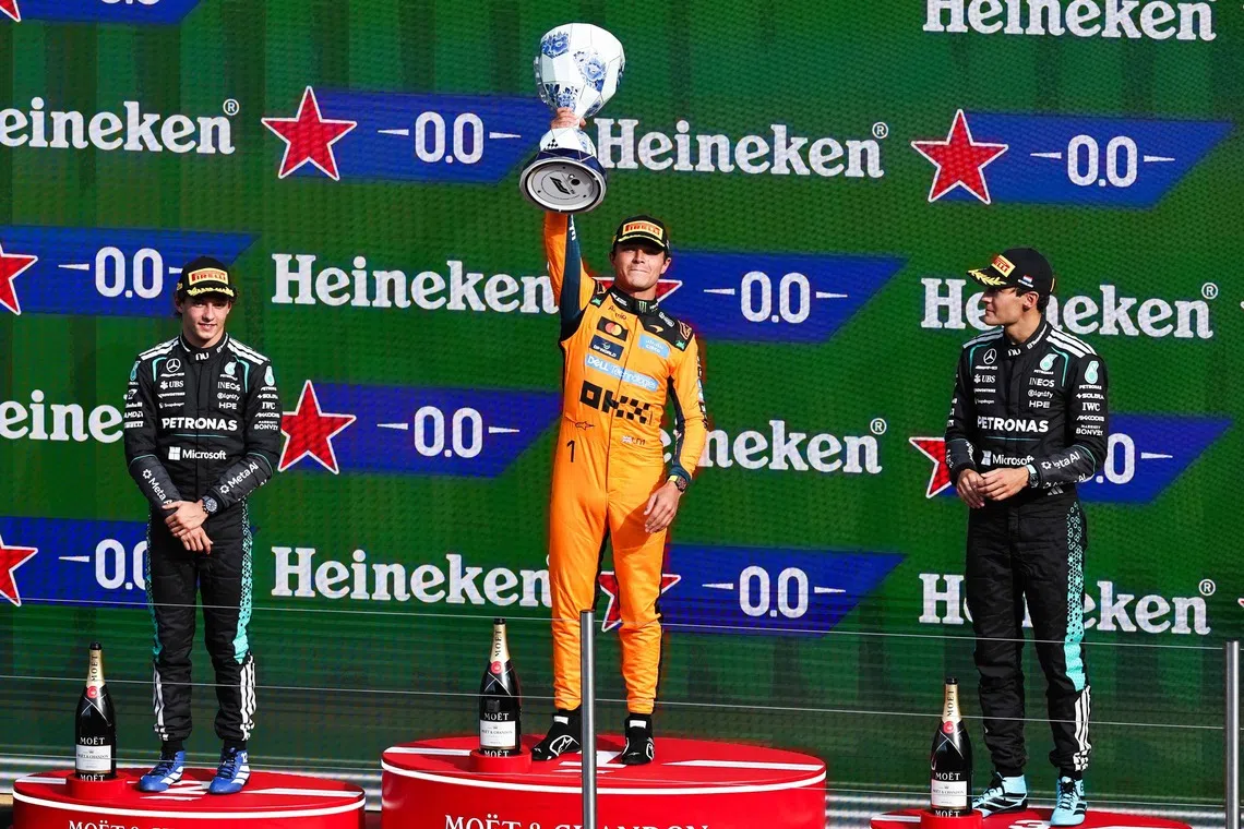 McLaren’s Lando Norris (centre) celebrates on the podium with Mercedes’ Kimi Antonelli (left) and George Russell after the Formula One Dutch Grand Prix on Aug 23.