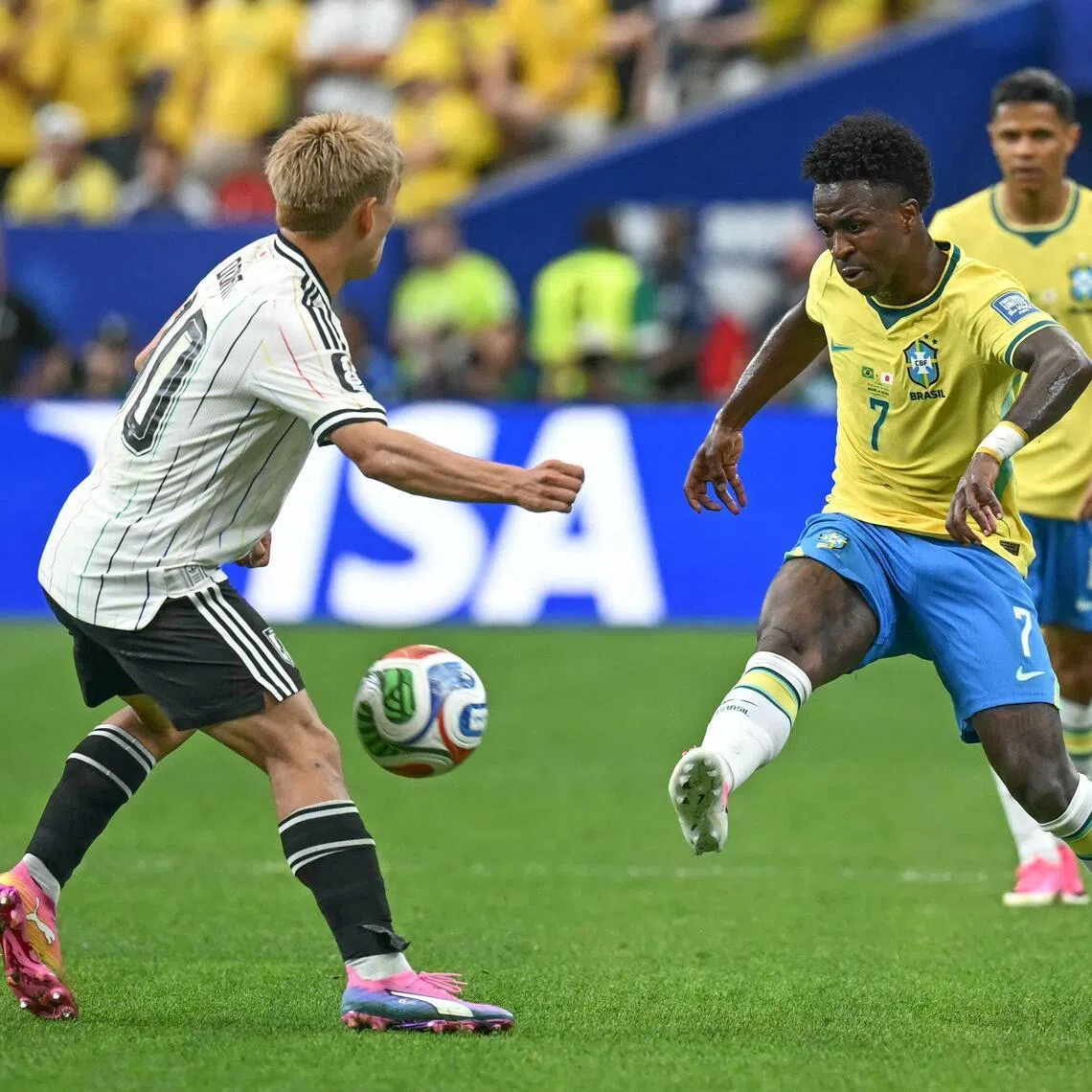 Brazil forward Vinicius Junior (right) fights for the ball with Japan midfielder Ritsu Doan during their World Cup round of 32 match at the Houston Stadium on June 29.
