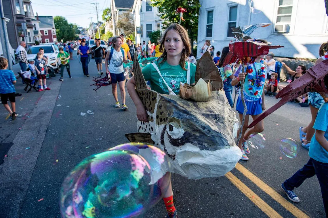 Children dress as fish and fisherman march during the Fishtown Horrible's Parade, ahead of Independence Day, in Gloucester, Massachusetts on July 3, 2023.