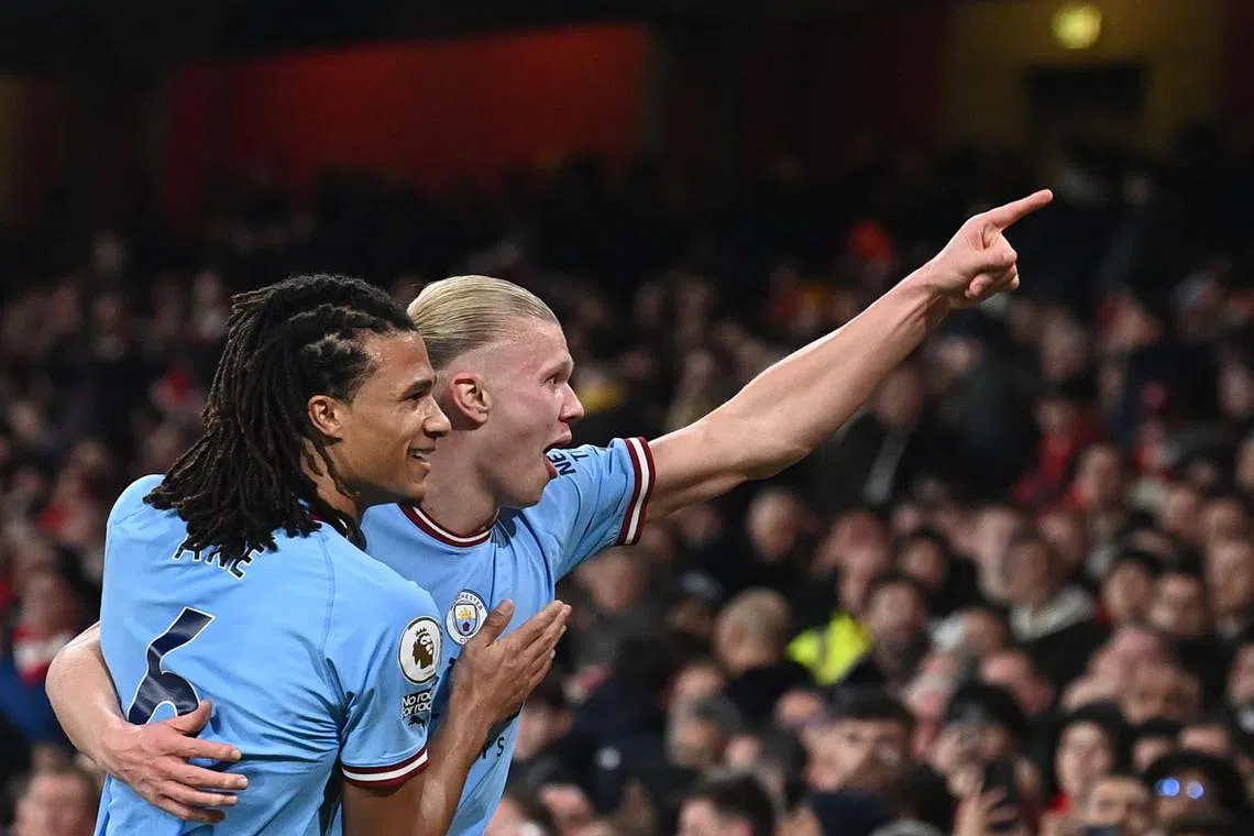 Manchester City's Erling Haaland (right) celebrates after scoring his team's third goal.