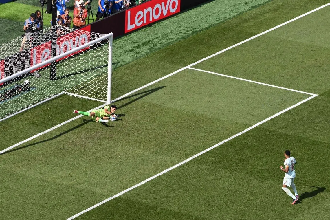 Morocco’s goalkeeper  Yassine Bounou saves a penalty kick by Kylian Mbappe.