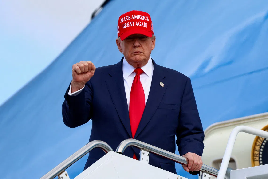 U.S. President Donald Trump gestures, while wearing a \"Make America Great Again\" cap, as he disembarks Air Force One, following his Asia trip, at Joint Base Andrews, Maryland, U.S., October 30, 2025. REUTERS/Evelyn Hockstein      TPX IMAGES OF THE DAY
