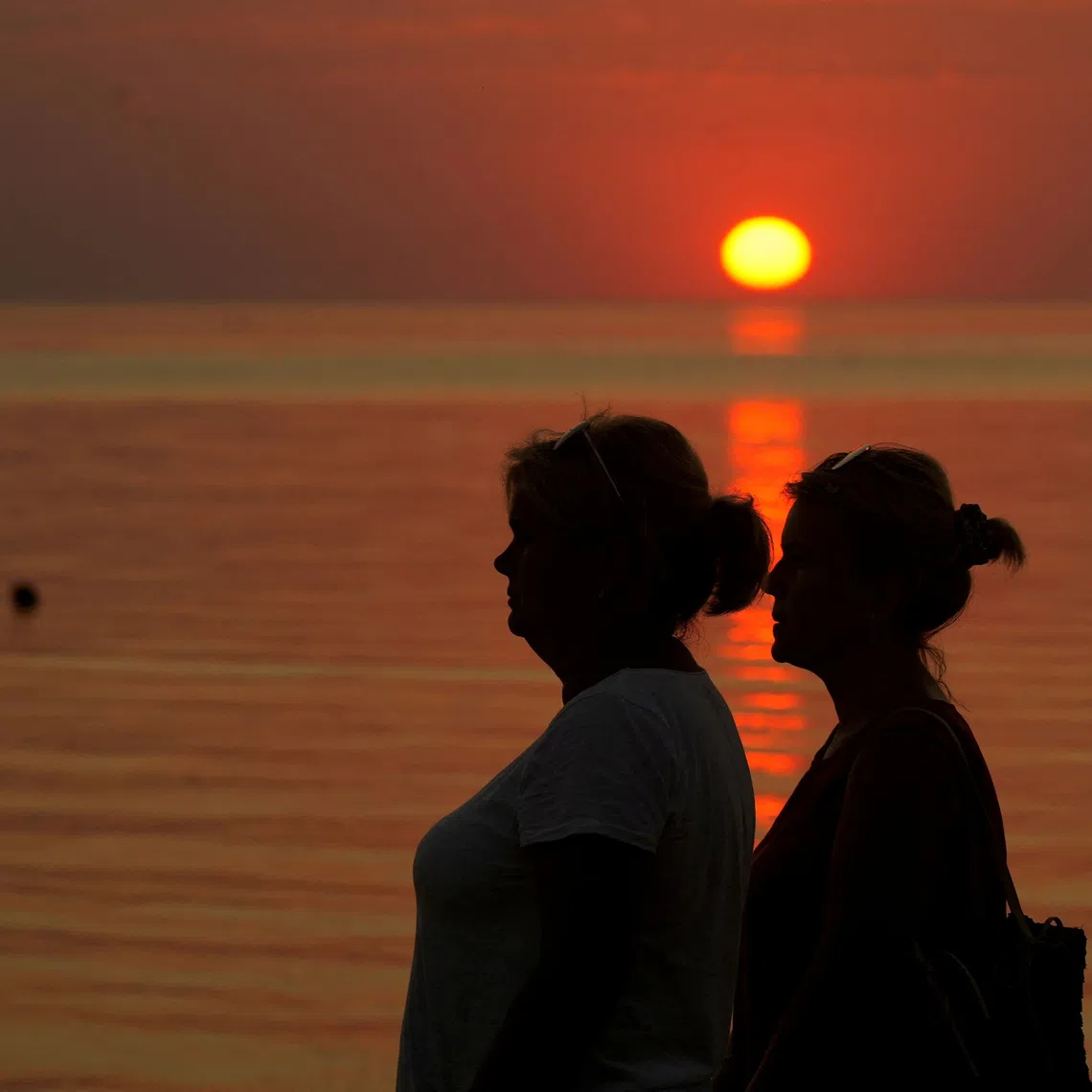 FILE PHOTO: People watch sunset on the seaside in Saulkrasti, Latvia August 27, 2022. REUTERS/Ints kalnins/File Photo