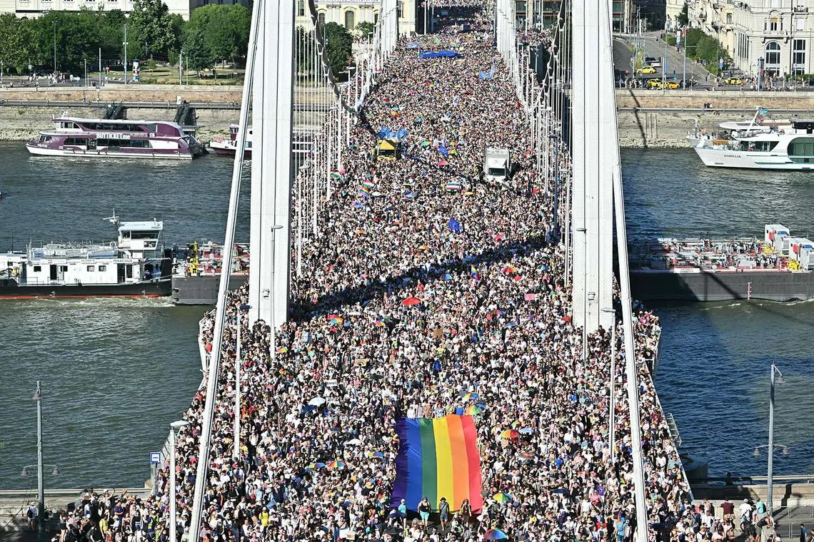 People carrying a rainbow flag as they take part in the Budapest Pride parade in Budapest downtown on June 28, 2025.