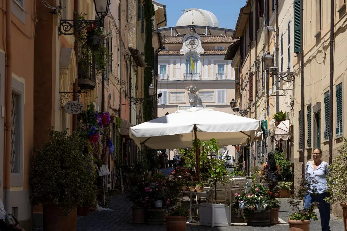 People walk in the town of Castel Gandolfo, near Rome, where Pope Leo will spend two weeks of vacation in July, Italy, July 1, 2025. REUTERS/Remo Casilli