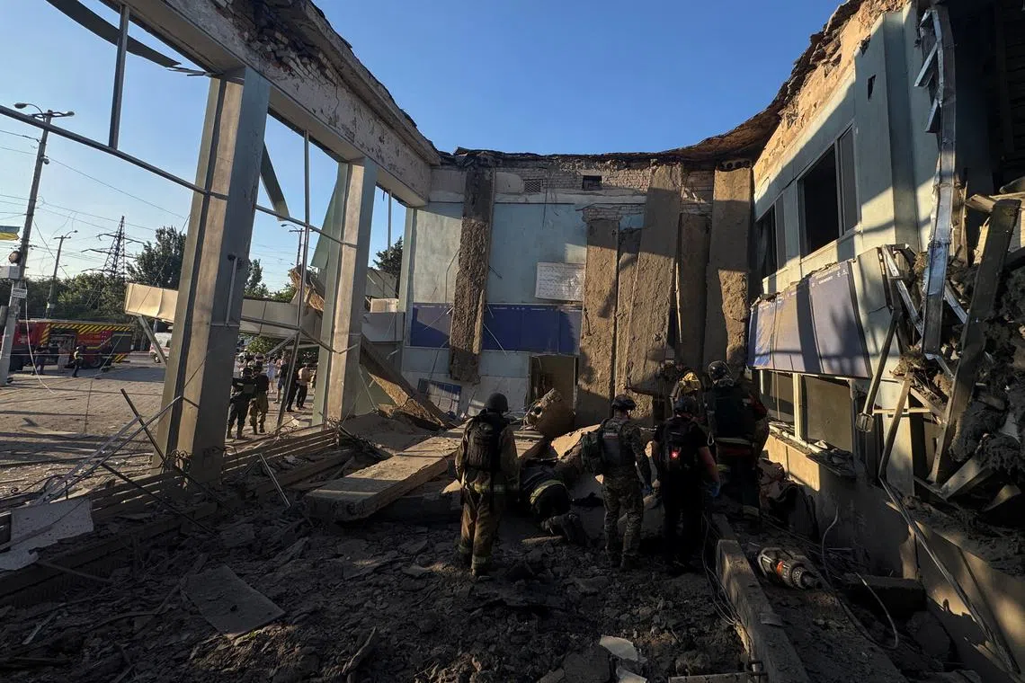 Rescuers and police officers work at the site of the Russian air strike, amid Russia's attack on Ukraine, in Zaporizhzhia, Ukraine August 10, 2025. REUTERS/Stringer