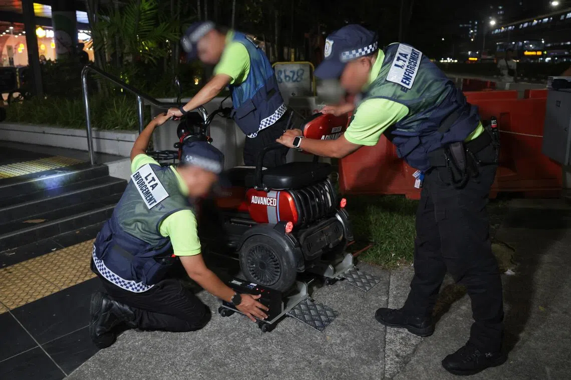 LTA enforcement officers using a speed measuring device to check whether a PMA exceeds the maximum speed limit of 10km/h during the enforcement checks in Northpoint City in Yishun on Aug 3.