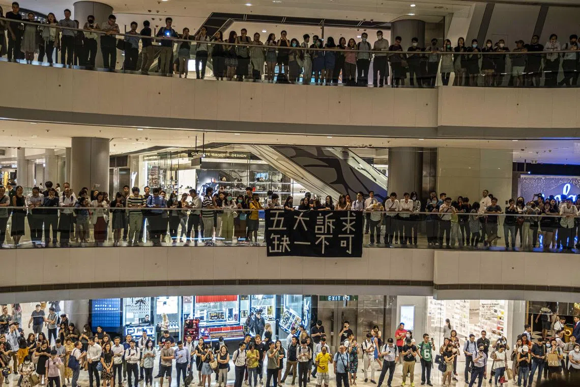 Protesters sing songs, including Glory To Hong Kong, during a demonstration at the IFC shopping mall in Hong Kong.