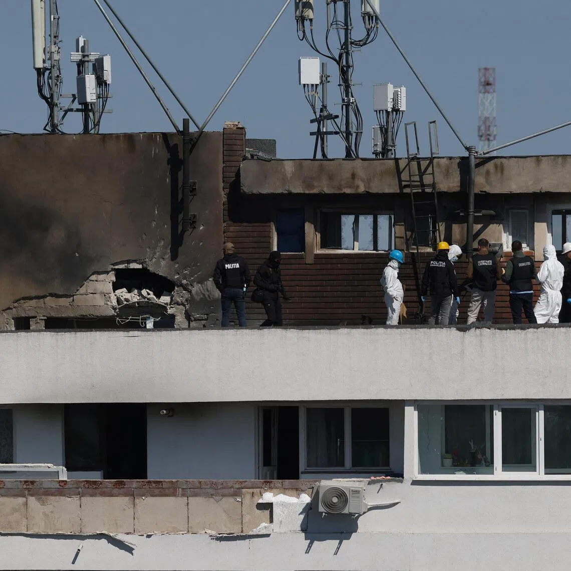 Romanian law enforcement officers working at the site of the drone explosion - a residential block of flats in Galati, Romania - on May 29.