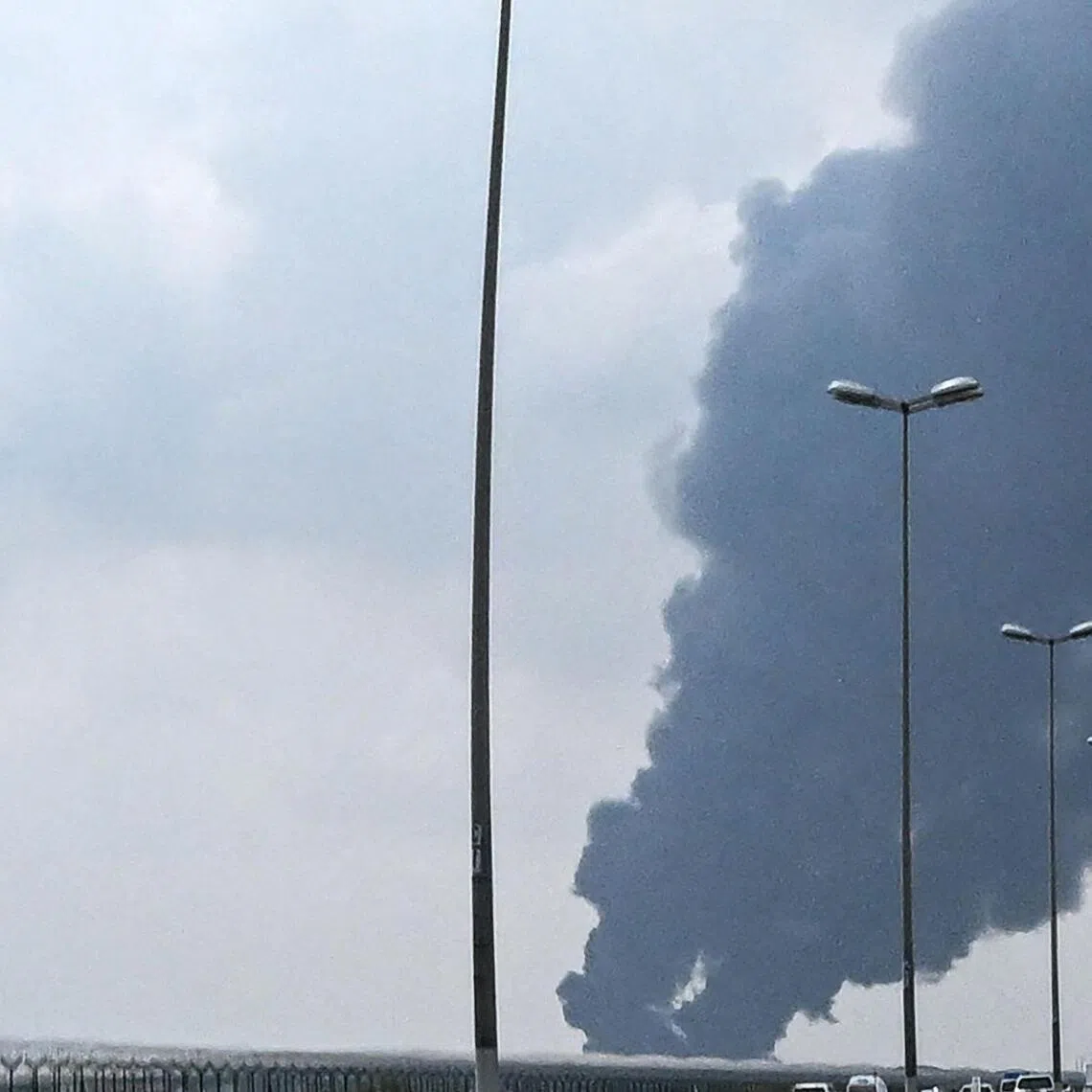 Smoke rises from the area of the Kuwait International Airport after a reported drone strike hit a fuel depot.