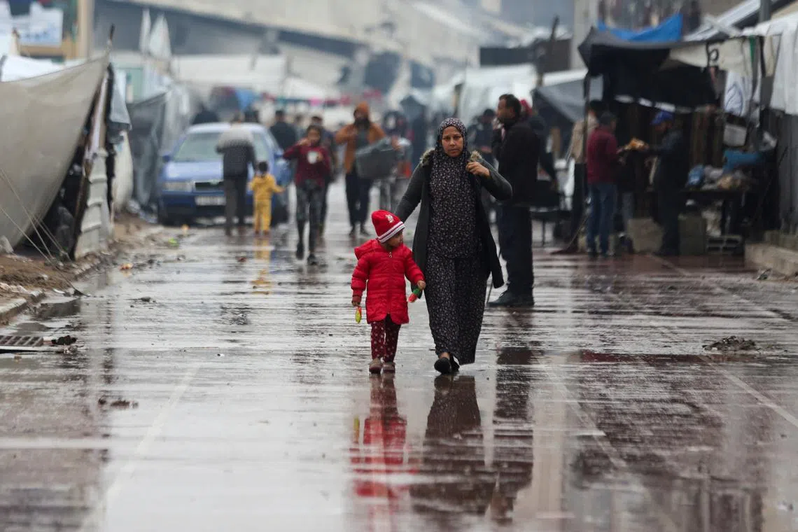 FILE PHOTO: Displaced Palestinians walk near tents following rainfall, amid the Israel-Hamas conflict, in Gaza City November 24, 2024. REUTERS/Dawoud Abu Alkas/File Photo
