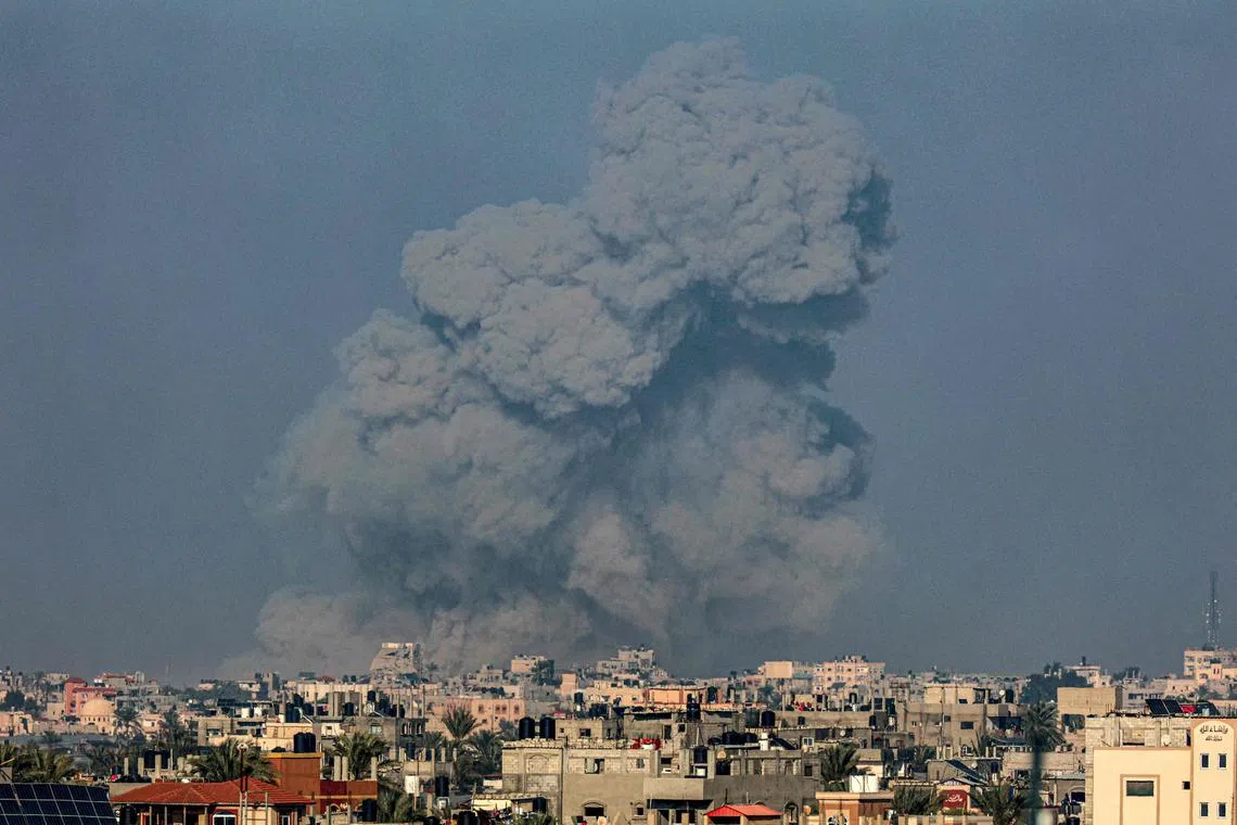 A picture taken from Rafah shows smoke billowing over Khan Younis, in the southern Gaza Strip, during Israeli bombardment.