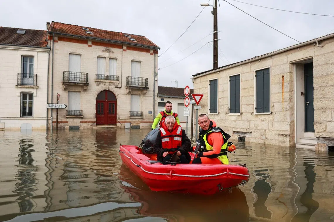 Rescuers navigating a flooded street in Saintes, western France, on Feb 18.