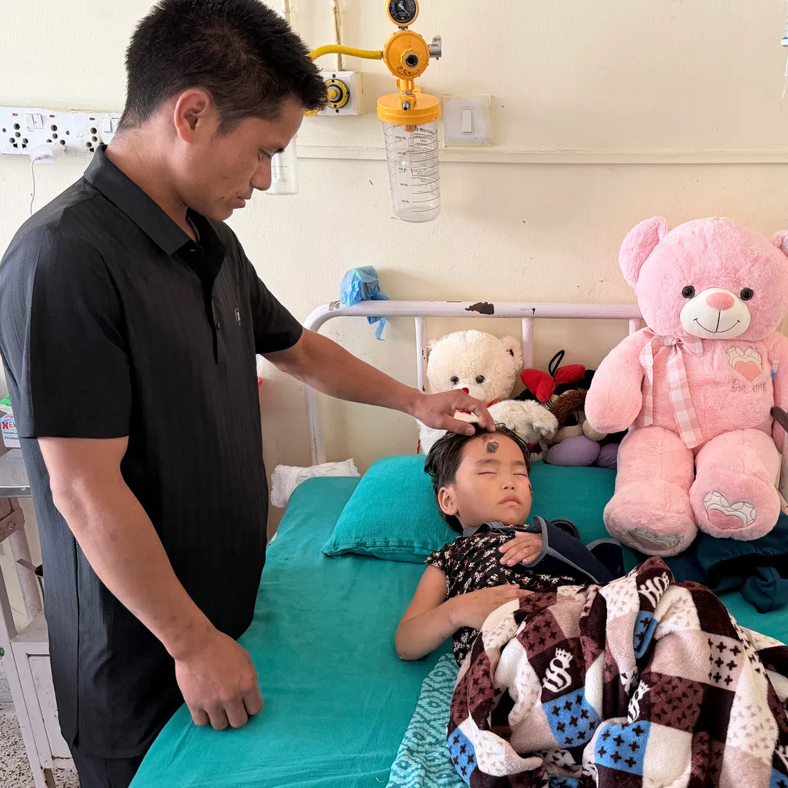 Manisha Magar with her father, Lokbahadur Magar, at the Tribhuvan University Teaching Hospital in Kathmandu, Nepal, on Aug 5. She survived some 60 hours of being buried under mud and debris.