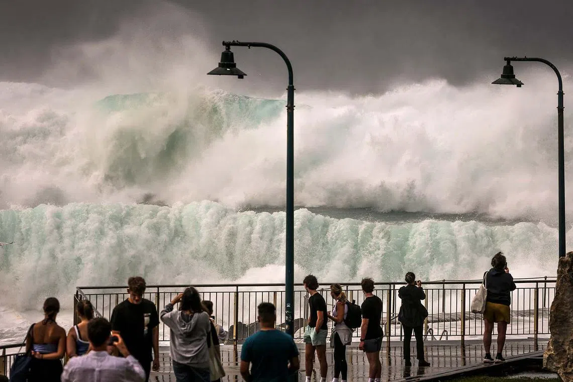 People watching large waves breaking at Bronte Beach in Sydney on April 1, 2025, as large swells and high winds hit the east coast of Australia. 