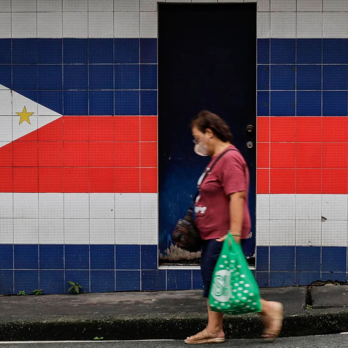 epa12416200 A person walks past an unused outpost for village patrol personnel in Mandaluyong City, Metro Manila, Philippines, 30 September 2025. Asian Development Bank (ADB) lowered its growth outlook for the Philippines from 6 percent to 5.6 percent for the year 2025 and from 6.1 percent to 5.7 percent for the year 2026, Asian Development Outlook (ADO) September 2025 report revealed.  EPA/ROLEX DELA PENA