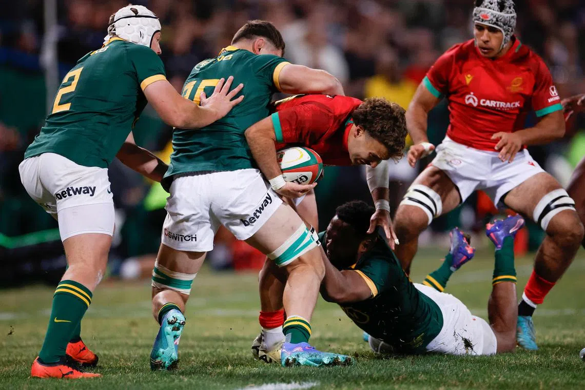 Portugal's full-back Jose Paiva dos Santos is tackled by South Africa's outside centre Lukhanyo Am (right) and loose forward Elrigh Louw in their International rugby union match at the Toyota Stadium in Bloemfontein on July 20, 2024.