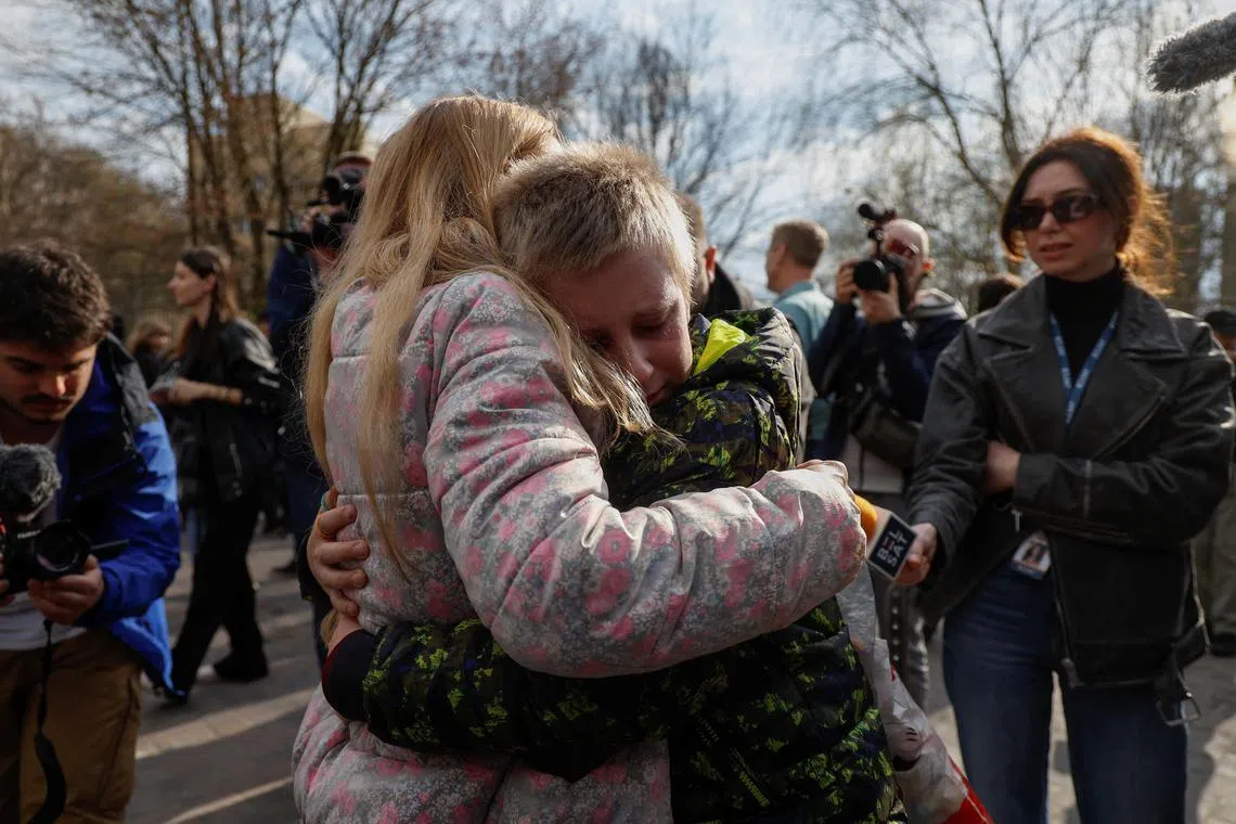 Iryna embraces her 13-year-old son, Bohdan, after he returns from Russia via the Ukraine-Belarus border.