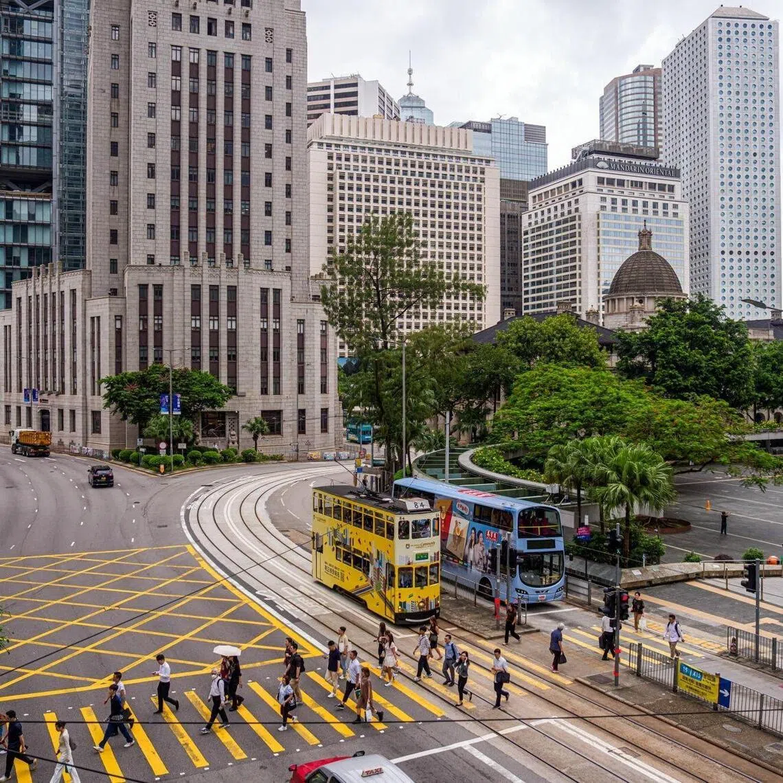 Pedestrians cross a road in Central district in Hong Kong, China, on Thursday, Aug. 7, 2025. Hong Kong raised its full-year growth forecast for 2025, signaling increased confidence in the economy’s momentum after exports and domestic consumption showed unexpected strength. Photographer: Lam Yik/Bloomberg