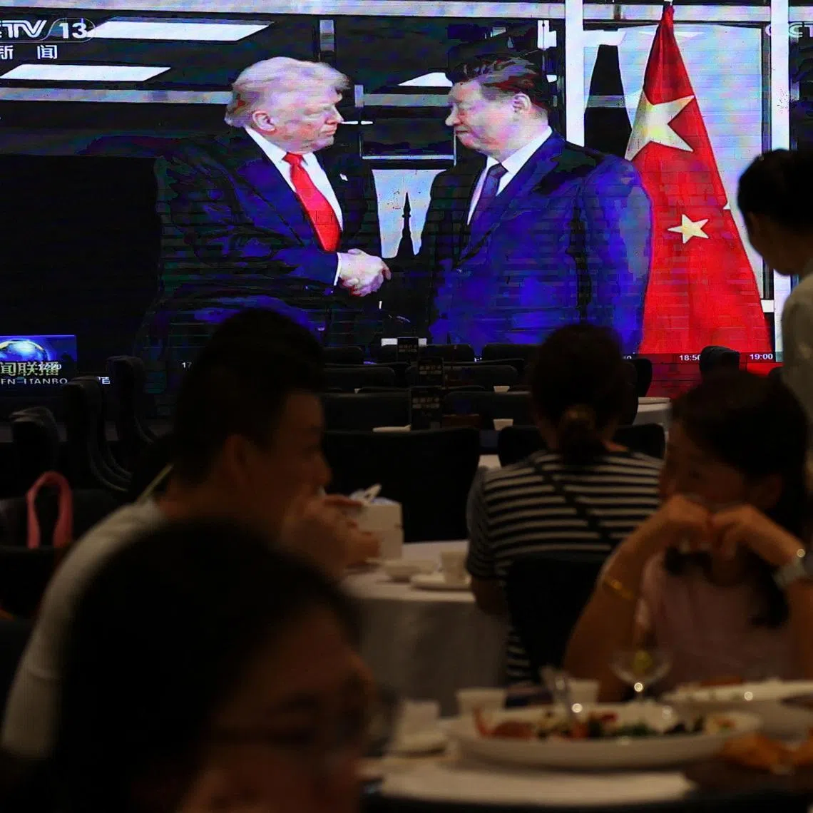 A screen shows news footage of the bilateral meeting between Chinese President Xi Jinping and U.S. President Donald Trump on the sidelines of the Asia-Pacific Economic Cooperation (APEC) summit in South Korea's Busan, at a restaurant in Shenzhen, Guangdong province, China October 30, 2025. REUTERS/Tingshu Wang