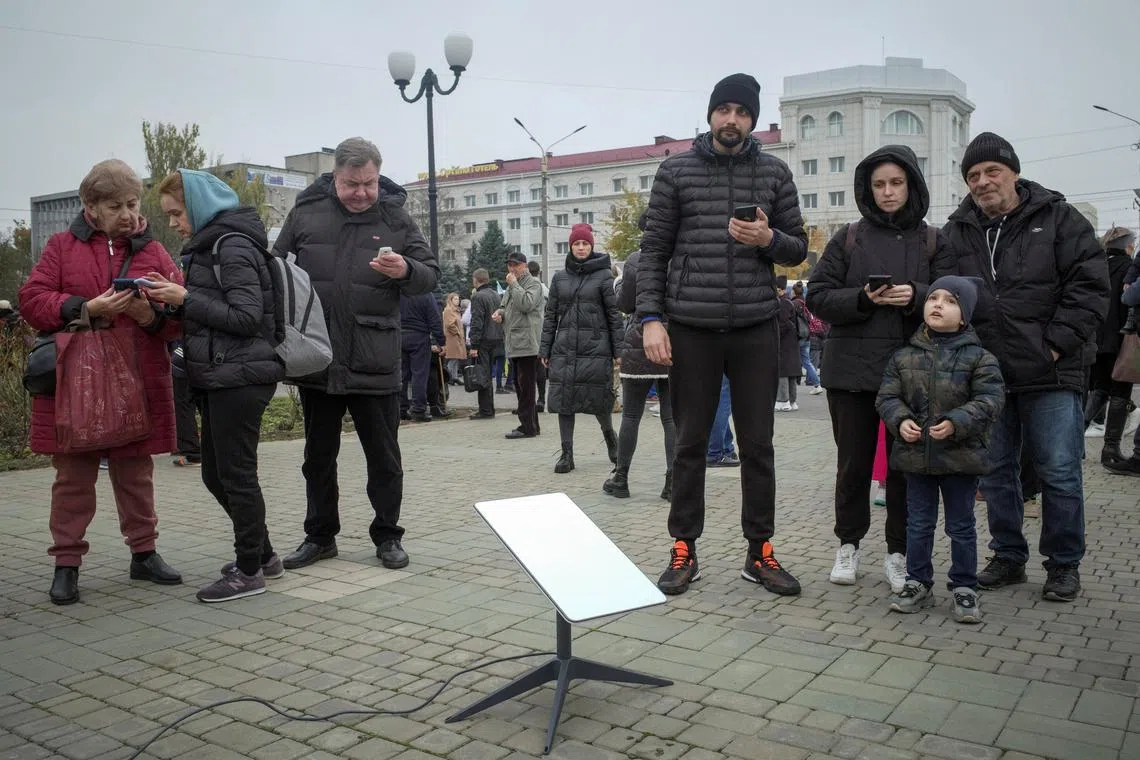 A 2022 photo shows Ukrainians using a Starlink terminal after Russia's retreat from the Ukrainian city of Kherson.