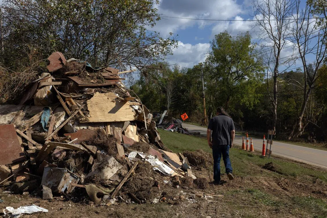 Joe Rogers walks past a pile of debris and belongings near the site of his former mobile home, in Clyde, N.C., after Hurricane Helene, Oct. 6, 2024. Millions of Americans, many poor and vulnerable, live in mobile and manufactured homes, but when catastrophe strikes, theyÕre often on their own. (Caitlin Ochs/The New York Times)