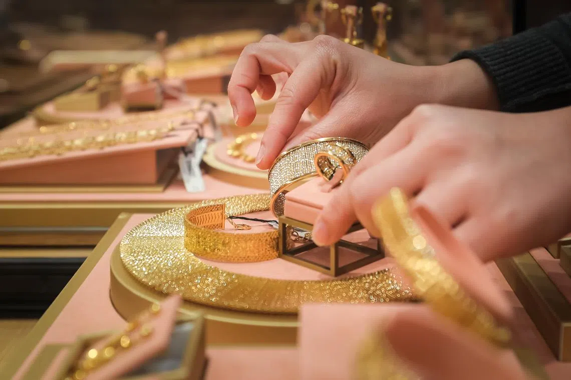 A Jewellery Advisor with gold at the Goldheart store in Ion Orchard, 11 Nov 2022.